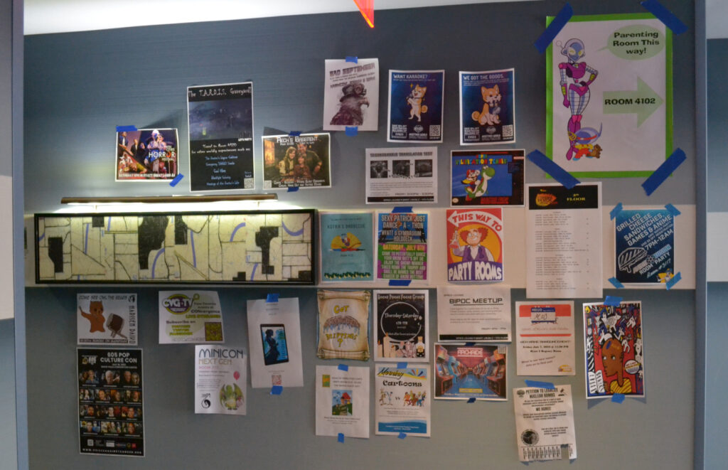 Many different posters on the wall at CONvergence 2023